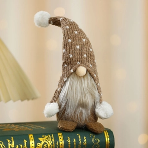 Macro detail of Christmas gnome with polka dot knit hat sitting on vintage book