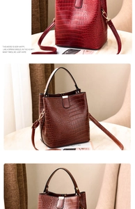 Detailed view of crocodile embossed pattern on water bucket bag with gold metal hardware