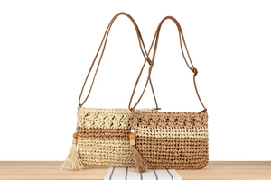 Détail de sacs en corde de papier tissés à la main avec pompons et perles en bois