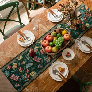 Close-up of green Christmas table runner with festive jacquard Merry Christmas patterns