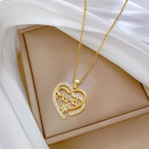 Vue macro d'un pendentif coeur doré avec lettrage MAMA et incrustation de zircons sur écrin