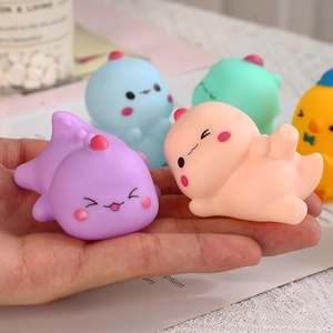 Set of colorful soft vinyl dinosaur and animal squeeze toys held in a hand for size comparison