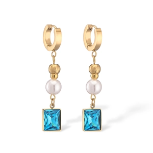 Detail of gold-plated earrings featuring white pearls and square blue zircons