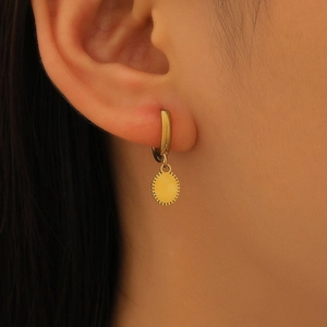 Gros plan de boucles d'oreilles pendantes géométriques dorées au look élégant
