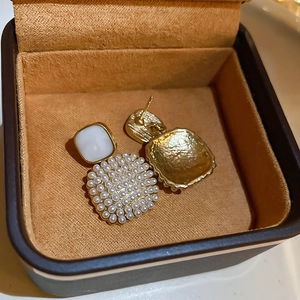 Detail of square gold pearl earrings showing brushed metal back and silver pins