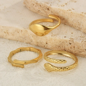 Dreiteiliges goldenes Ring-Set mit Schlangen-, Bambus- und Siegelring-Design auf Stein