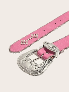 Detailed view of pink croc-effect belt with floral embossed silver buckle and metal studs