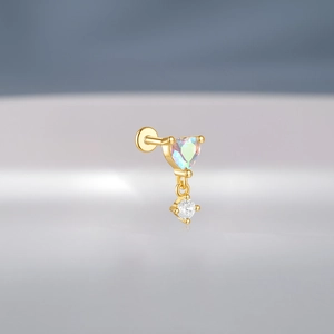 Macro detail of gold S925 silver earring with heart-shaped iridescent gem and round zircon