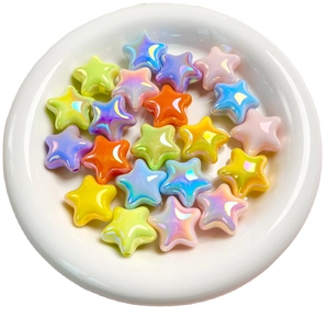 Mix of colorful UV plated star beads in a white ceramic dish for DIY jewelry making