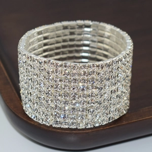 Macro shot of silver-colored multi-row rhinestone bridal stretch bracelet on wood