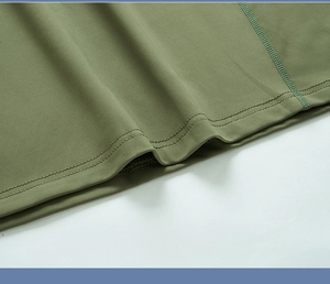 Macro de l'ourlet de sweat olive montrant la double surpiqûre et la finition de surjetage