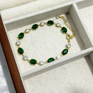 Détail du bracelet émeraude ovale avec fermoir mousqueton et chaîne de réglage doré