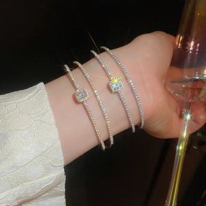 Close-up of sparkling zircon bow double-layer bracelet set in elegant social scene
