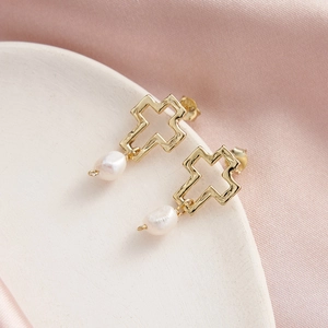 Détail du poinçon S925 sur les boucles d'oreilles croix dorées et perle naturelle