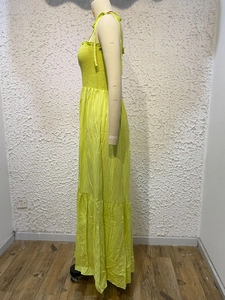 Close-up of bright yellow pleated maxi dress with tiered skirt and elastic texture
