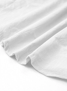 Macro detail of white cotton linen fabric texture and stitching on men's casual shirt
