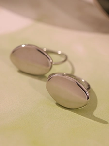 Detail view of oval minimalist rings with high-polish mirror finish in silver stainless steel