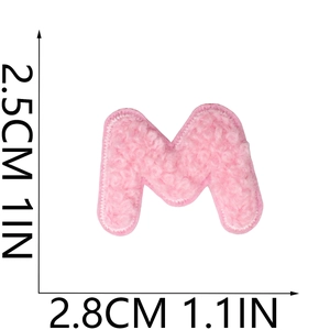 Detail of pink chenille letter M patch with plush texture and embroidered edges