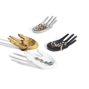 Elegant hand-shaped jewelry stand with embossed patterns in gold silver black and white