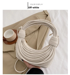 Detailed close-up of beige knotted underarm bag with unique spiral texture and zipper