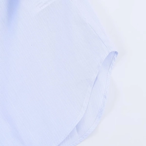 Detail of light blue plaid shirt featuring curved hem stitching and twill fabric texture