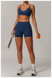 Mannequin portant un ensemble short de yoga taille haute bleu marine et brassière sport