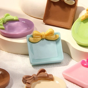 Close-up of miniature resin plates with bows for DIY dollhouse and fridge magnets