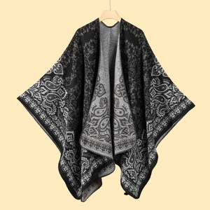 Detailed hanging shot of black and gray paisley knit shawl with intricate plant patterns