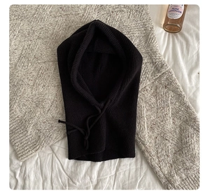 Detail of black knitted balaclava with adjustable drawstrings and soft texture