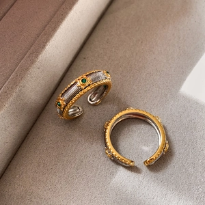 Detailed macro view of vintage gold and silver rings with green emerald-colored stones