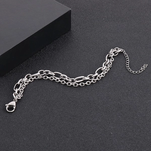 Close-up of double-layered stainless steel chain bracelet with lobster clasp on black background