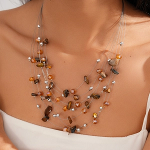 Detail of layered bohemian necklace with tiger eye beads and silver tassel strands