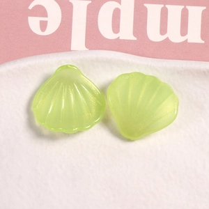 Primer plano de colgantes de concha de resina verde lima con brillo en plato blanco