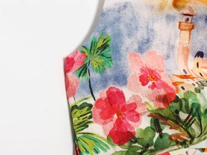 Detail of floral chiffon fabric with pink flowers and green palm prints on a midi skirt