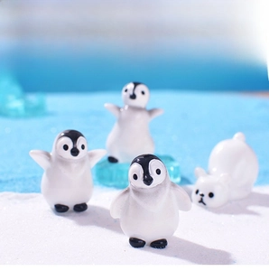 Macro view of resin penguin and polar bear figurines on a blue ice glacier scene