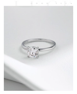 Close-up of square cut moissanite engagement ring with classic four-prong setting in silver