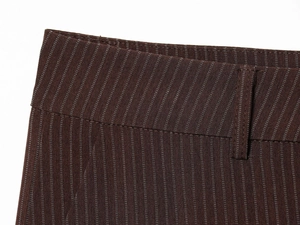 Gros plan du tissu à fines rayures marron foncé montrant les coutures et les passants de ceinture