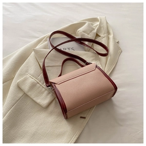 Detail of pink and burgundy patchwork leather handbag with litchi grain texture