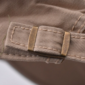 Detail of vintage canvas flat cap back strap with bronze adjustable metal buckle