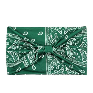 Detail of dark green paisley elastic headband with soft knit texture and twisted knot