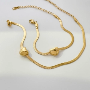 Macro detail of gold snake chain with heart pendant and K18 hallmark stamp