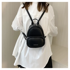 Rear view of a mini black PU leather backpack worn over a white casual shirt