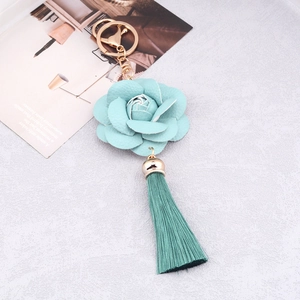 Detail of mint green PU leather flower keychain with matching tassel and gold hardware
