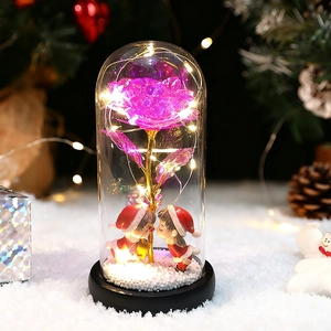 Cúpula de cristal navideña con rosa púrpura iridiscente y LED sobre base de nieve