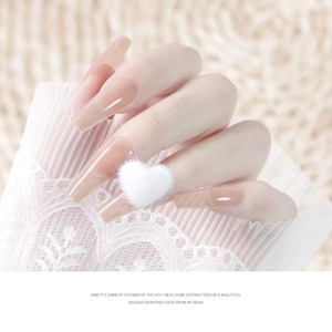Long trapezoid nude press-on nails featuring a white fuzzy plush heart on a sweater texture