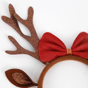 Christmas reindeer antler headband with red bow and brown glitter details on white background