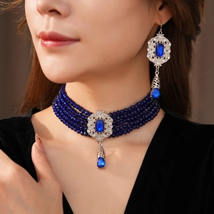 Close-up of vintage deep blue multi-layer beaded necklace and matching earring set
