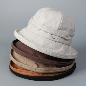 Detailed stack of linen bucket hats in five neutral colors with metallic logo detail