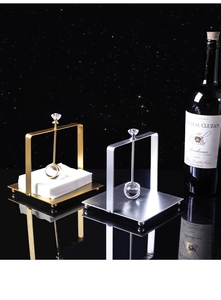 Detail of metal napkin holder with crystal ball gravity arm on polished surface
