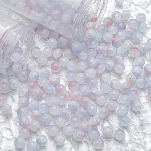 Macro shot of 10mm ice-cracked glass beads with pink and blue gradient for DIY jewelry